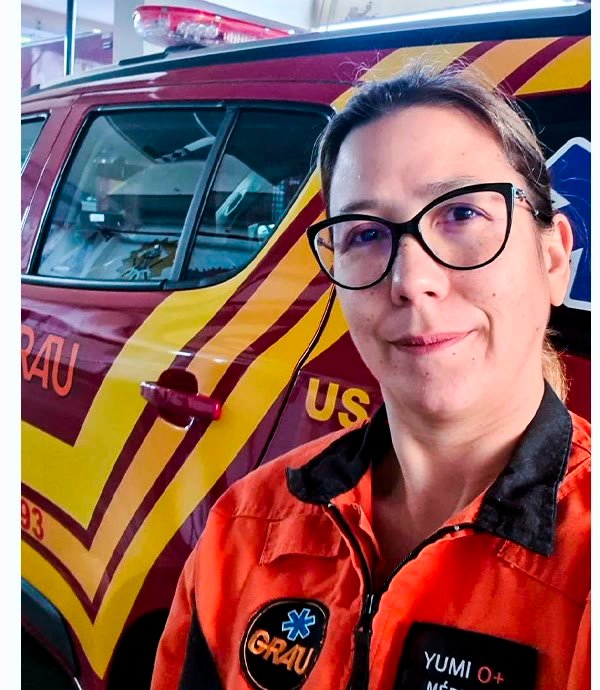 Dra. Yumi em atendimento no GRAU, em frente à ambulância